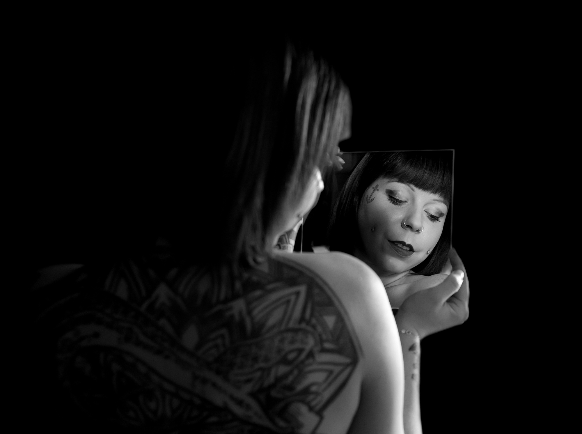 clair obscur d'une femme se regardant dans le miroir