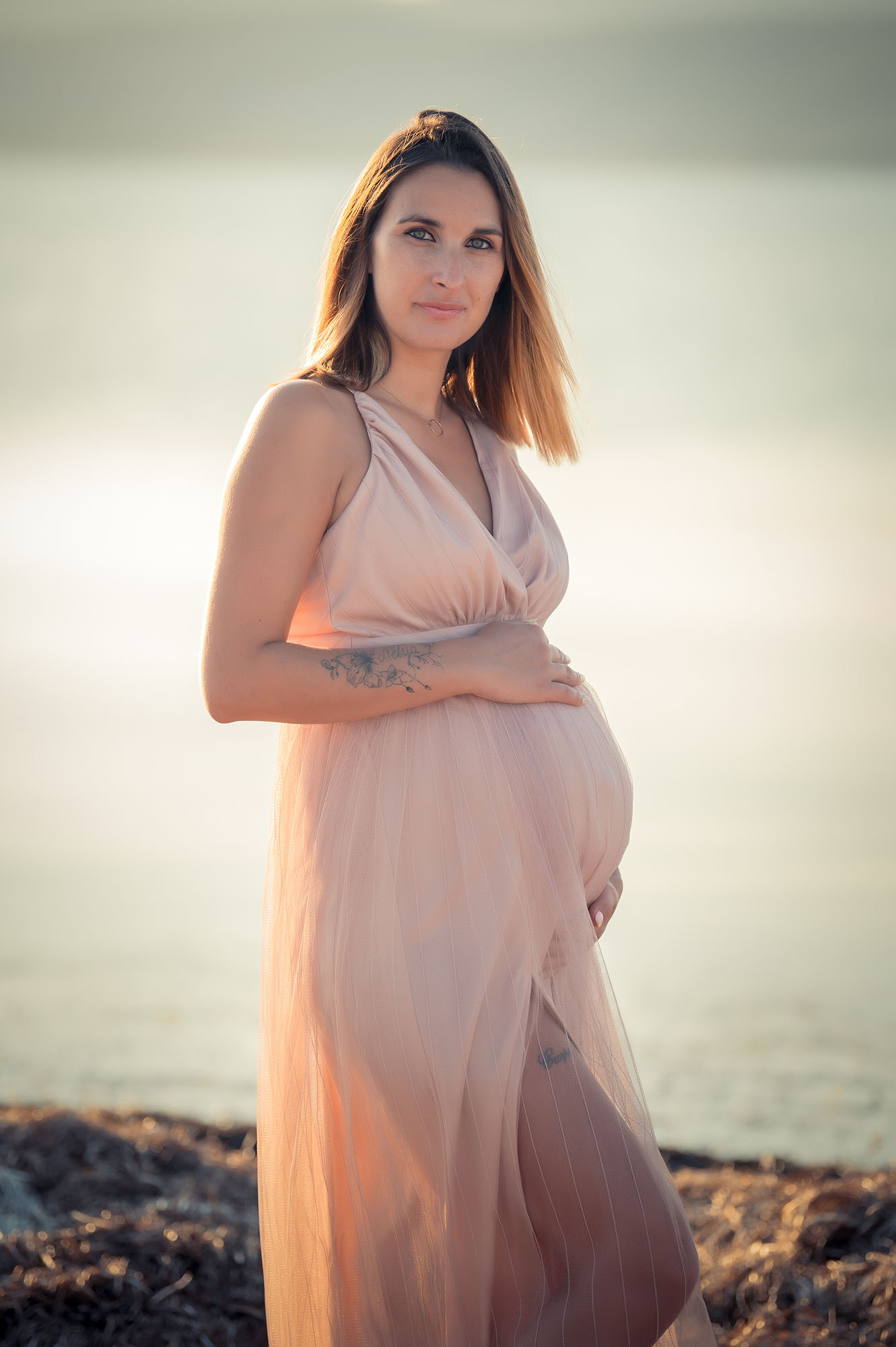 Portrait d'une femme enceinte en extérieur vêtue d'une robe rose