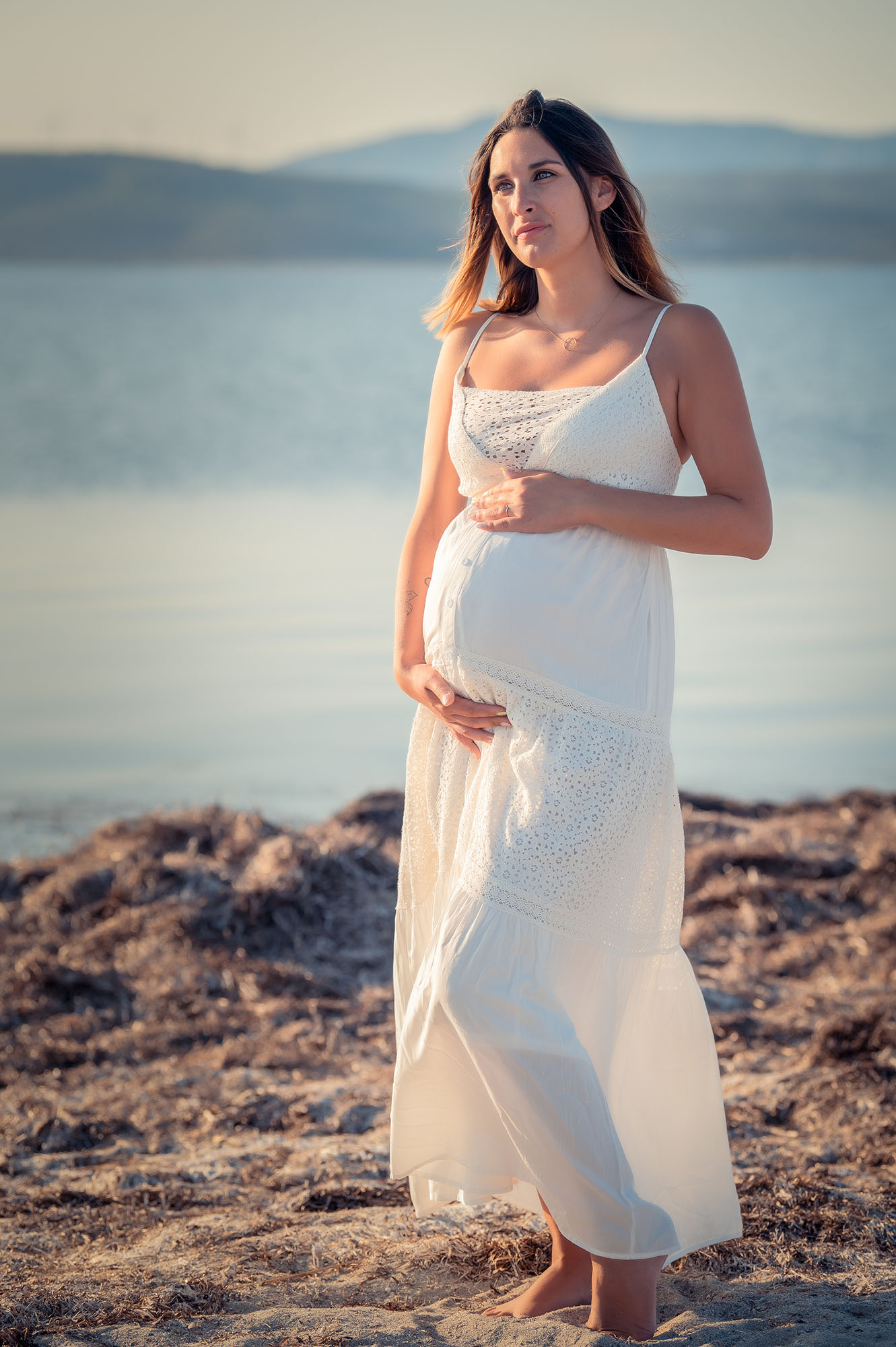 portrait d'une femme enceinte en extérieur vêtue d'une robe au coucher de soleil