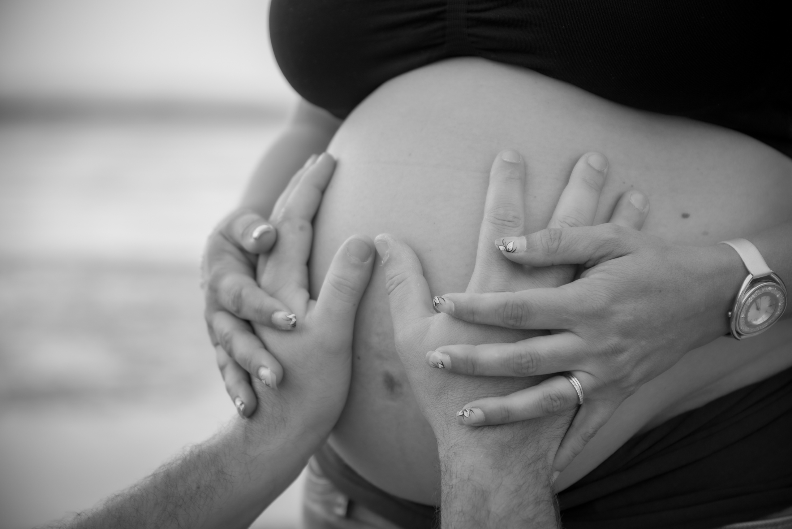 photo noir et blanc des mains posées sur le ventre d'une femme enceinte