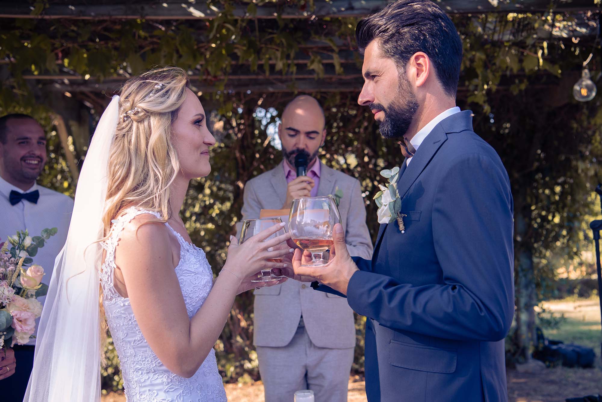 deux mariés en face à face avec un verre à la main