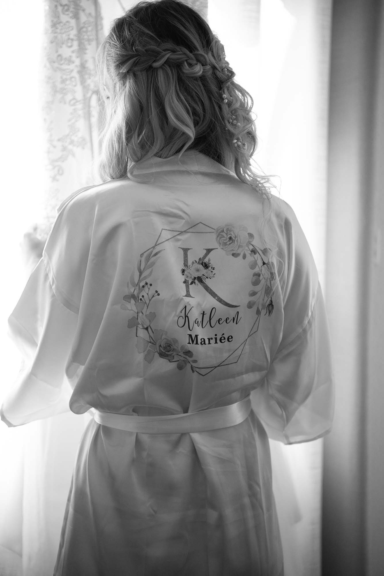 photo noir et blanc d'une mariée vue de dos avec un peignoir personnalisé