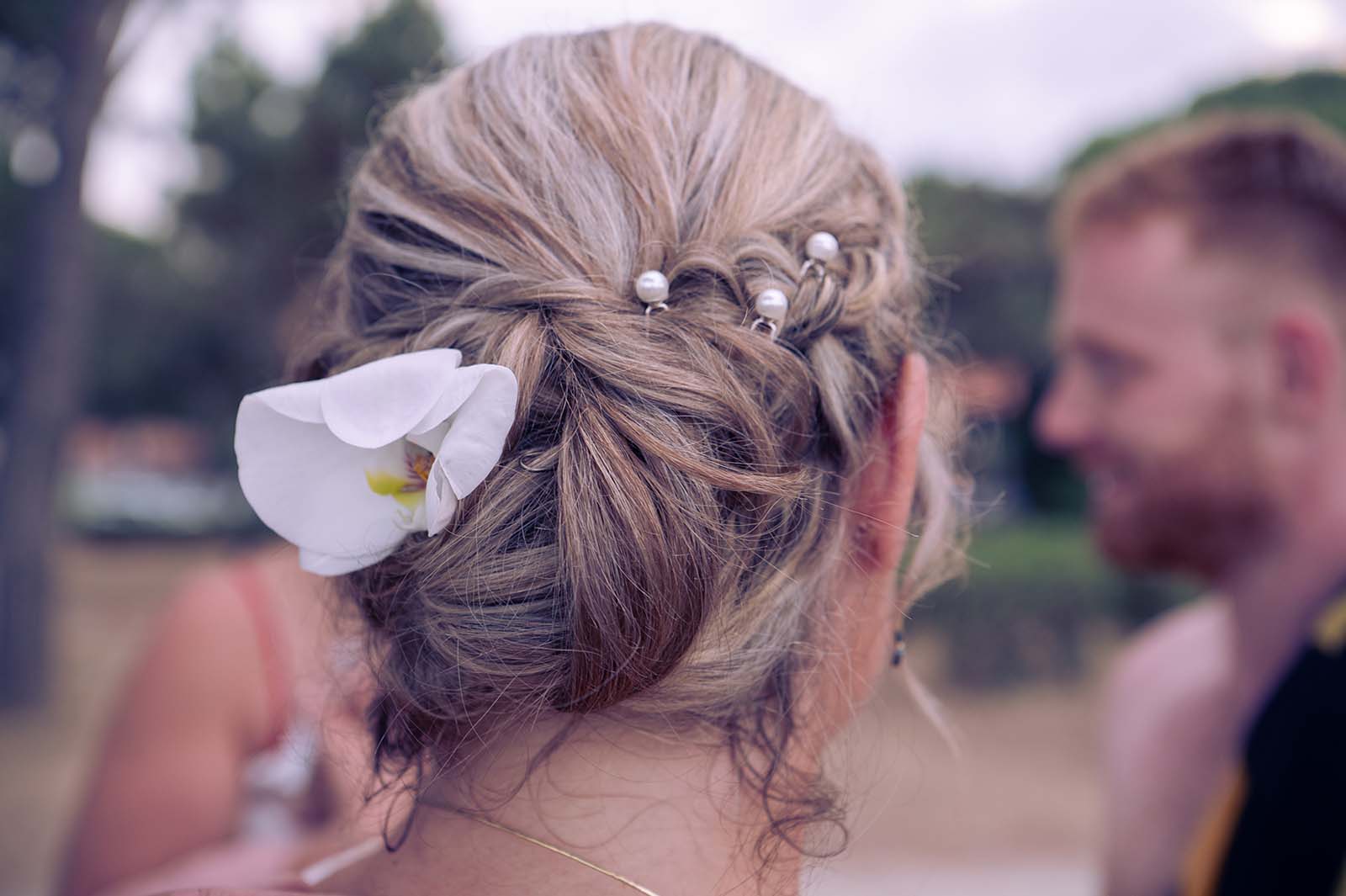 gros plan sur la coiffure d'une mariée avec une fleur blanche