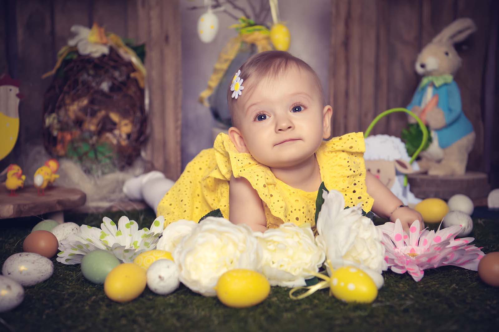 portrait d'une petite fille blonde allongée dans un décor de Pâques