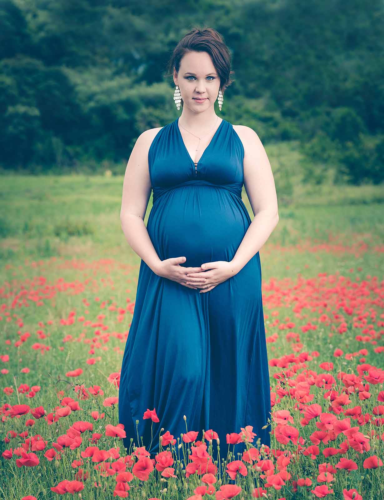 portrait d'une femme enceinte dans un champ de coquelicots