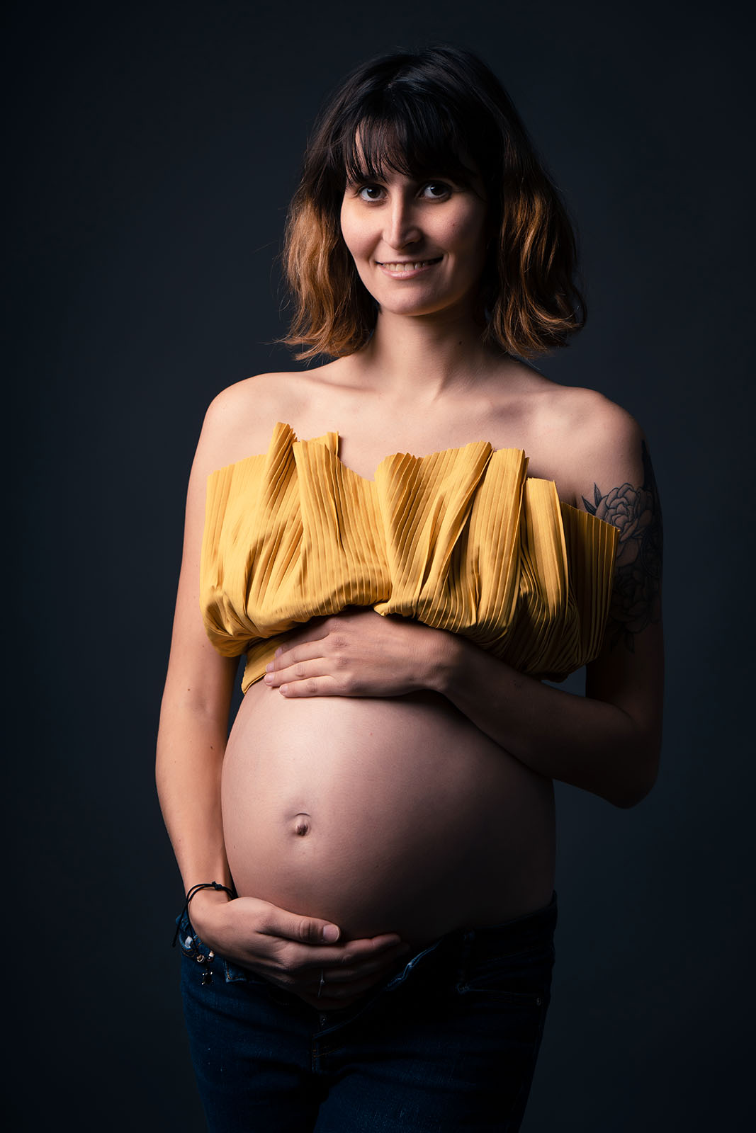 femme enceinte aux cheveux cours habillée avec un crop top jaune