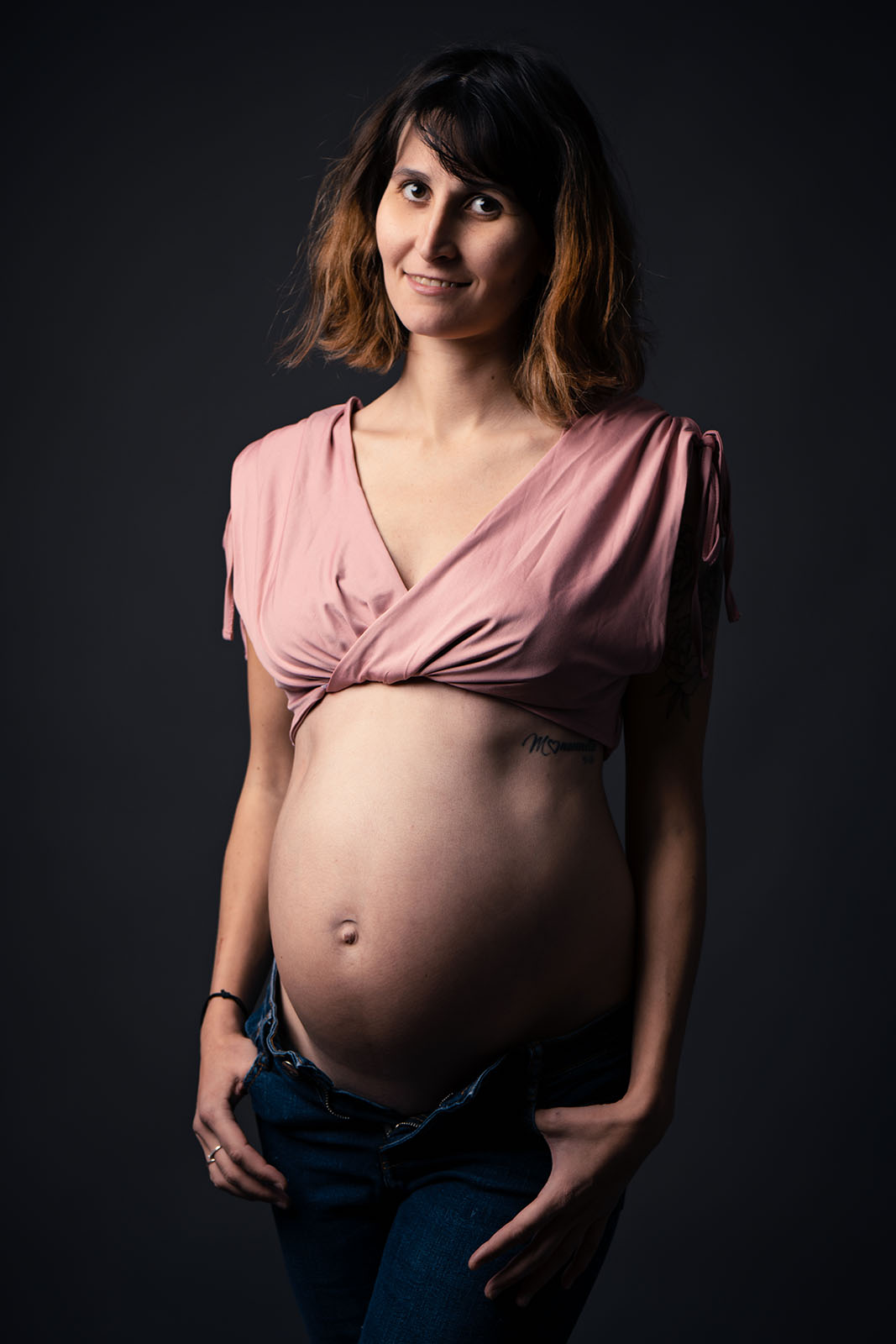 femme enceinte aux cheveux cours habillée avec un crop top rose