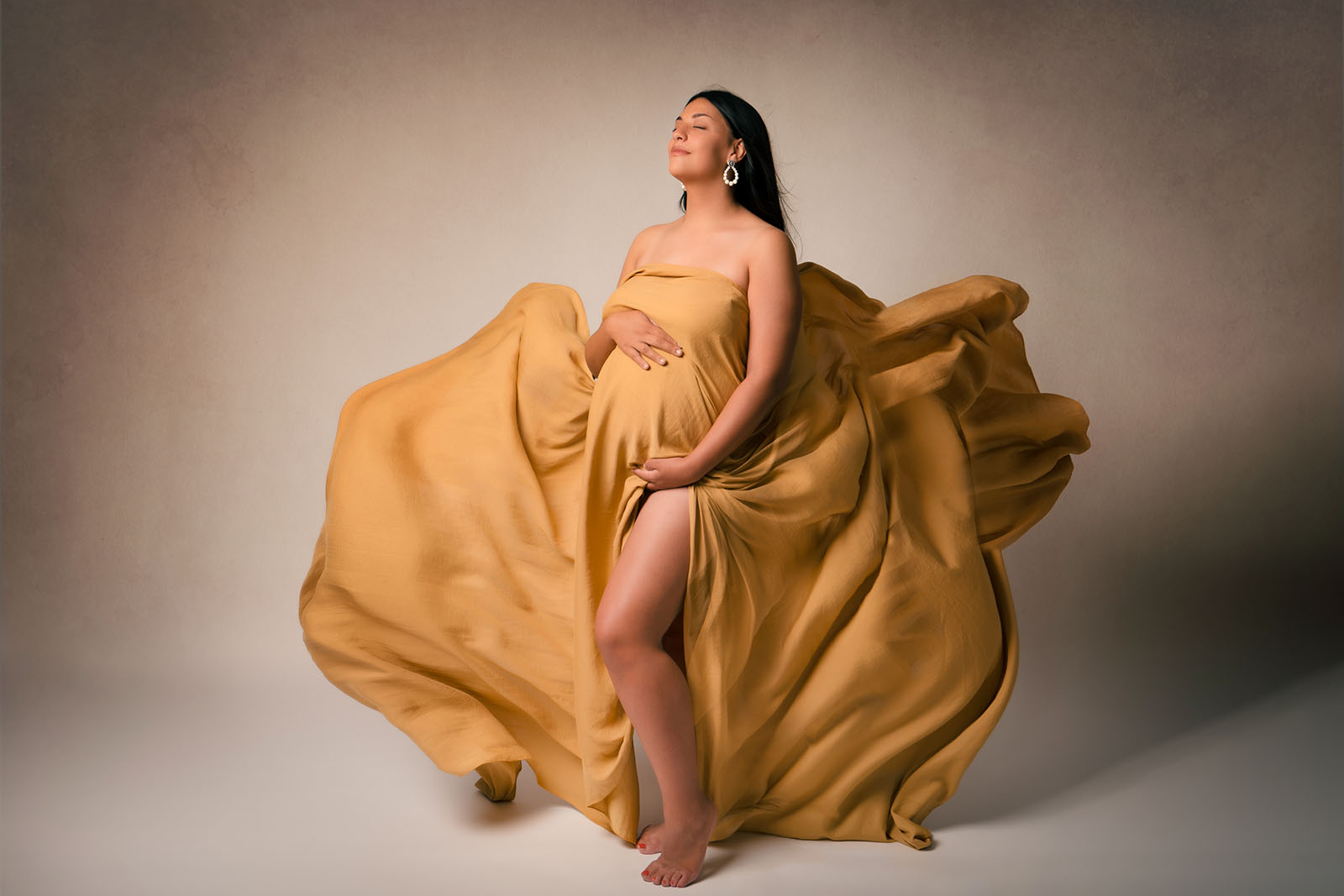 photo d'une femme enceinte habillée d'un voile jaune qui vole