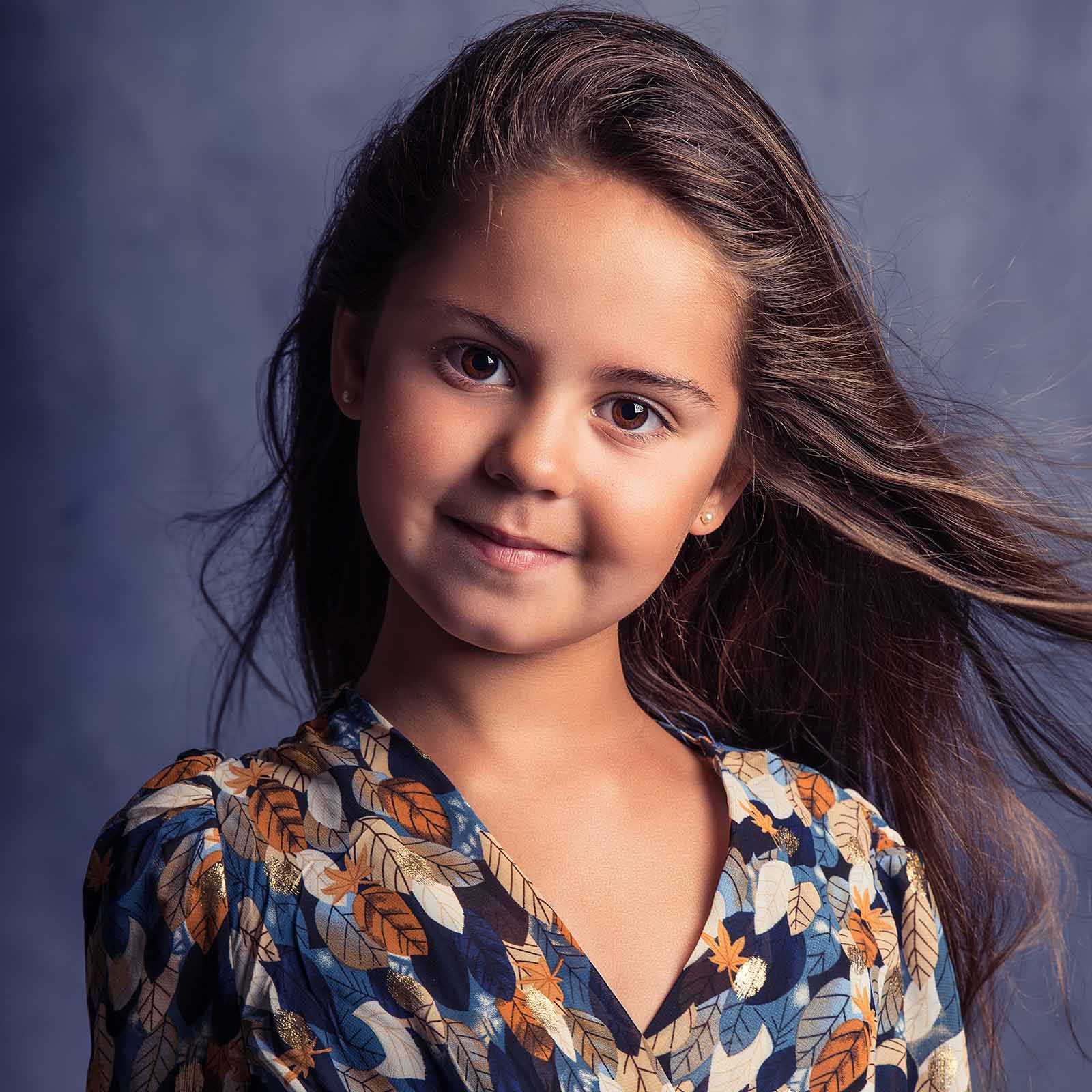 portrait studio d'une petite fille avec les cheveux qui volent