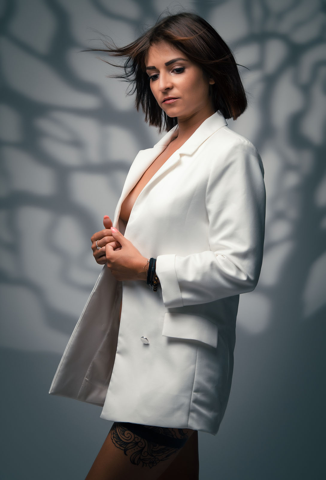 portrait d'une femme brune aux cheveux courts portant une veste de blazer blanc