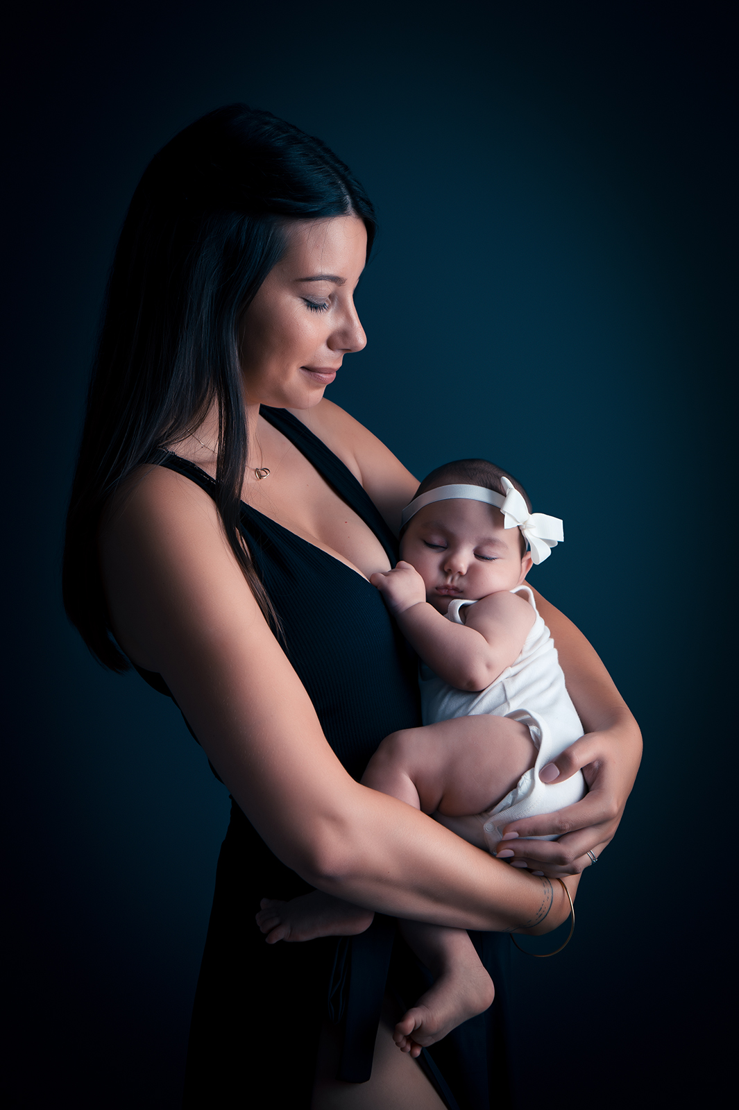 portrait studio d'une maman tenant son bébé dans les bras