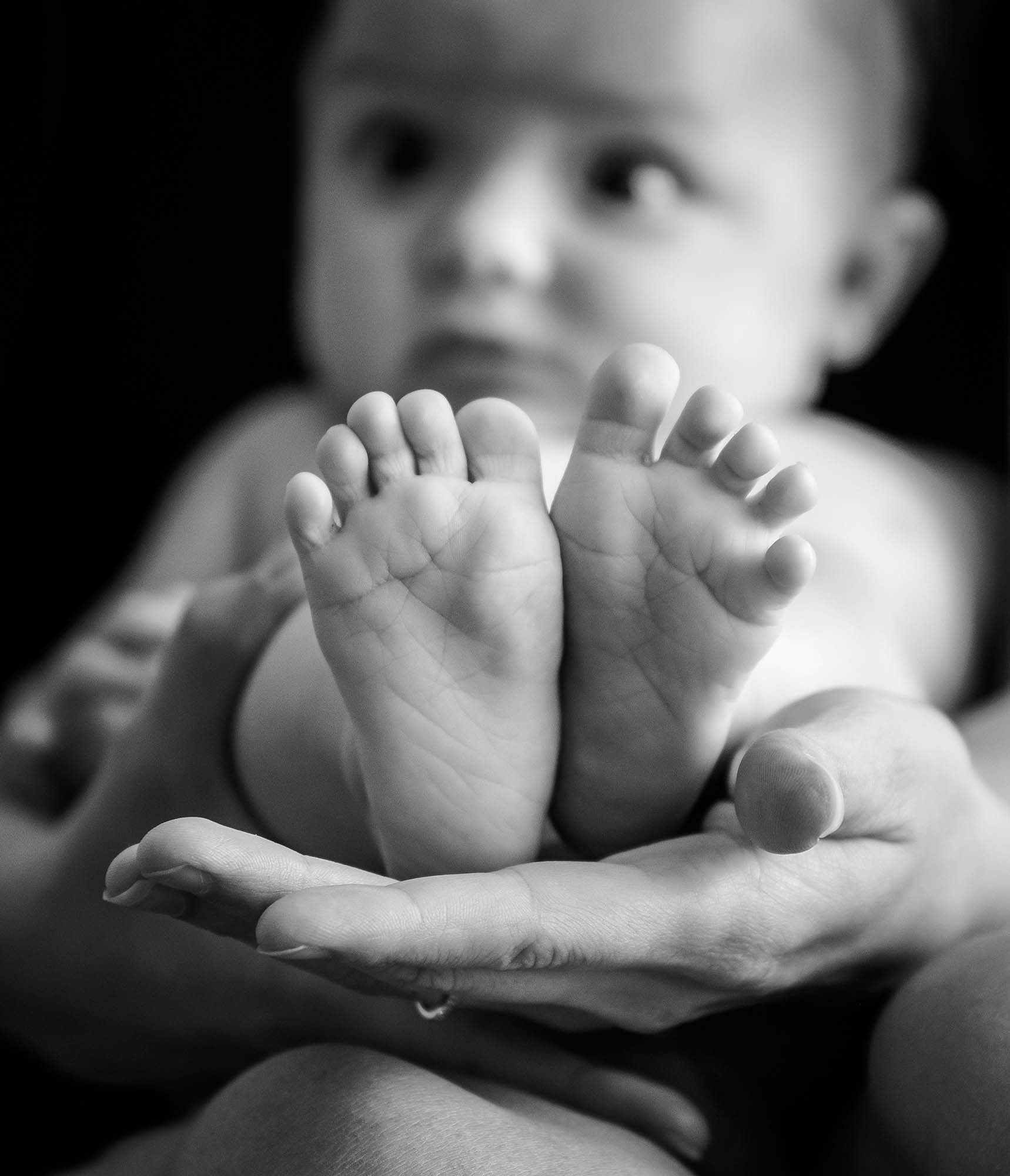 gros plan sur les pieds d'un bébé avec la tête de bébé flou en arrière plan
