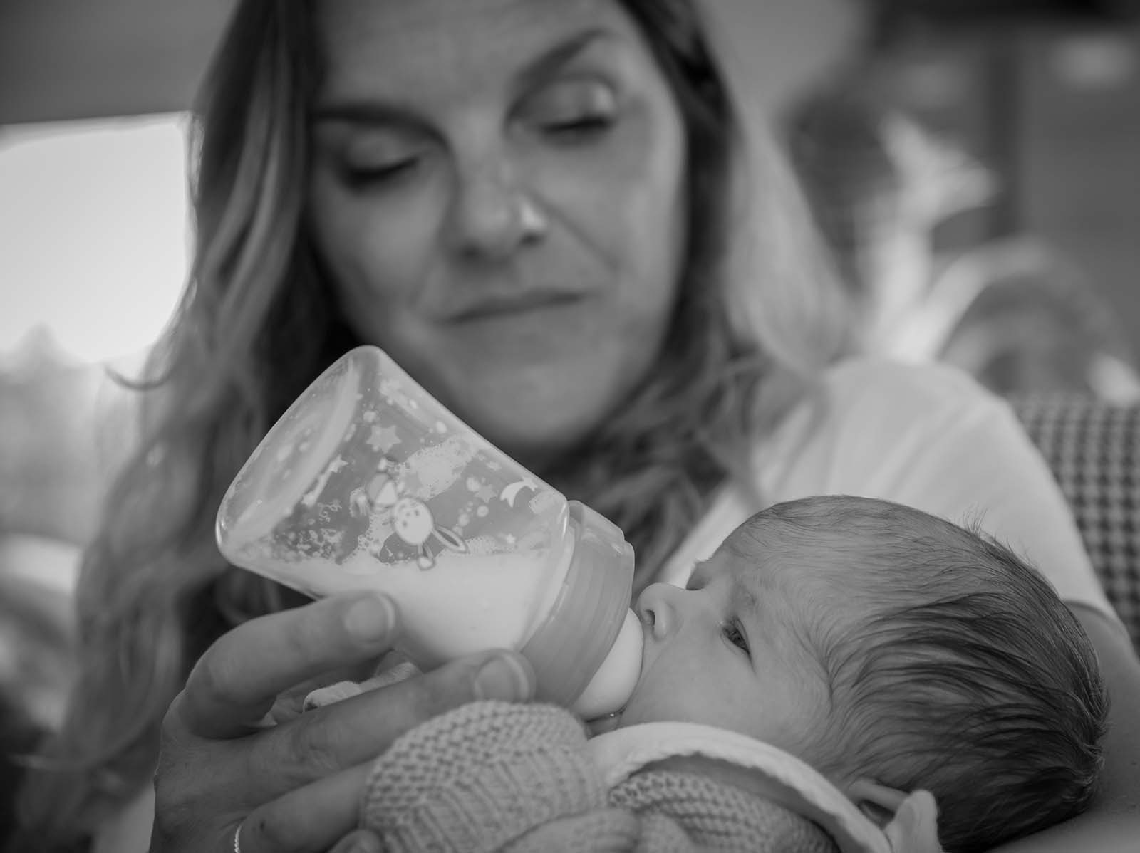 photographie noir et blanche d'une femme donnant le biberon a un bébé