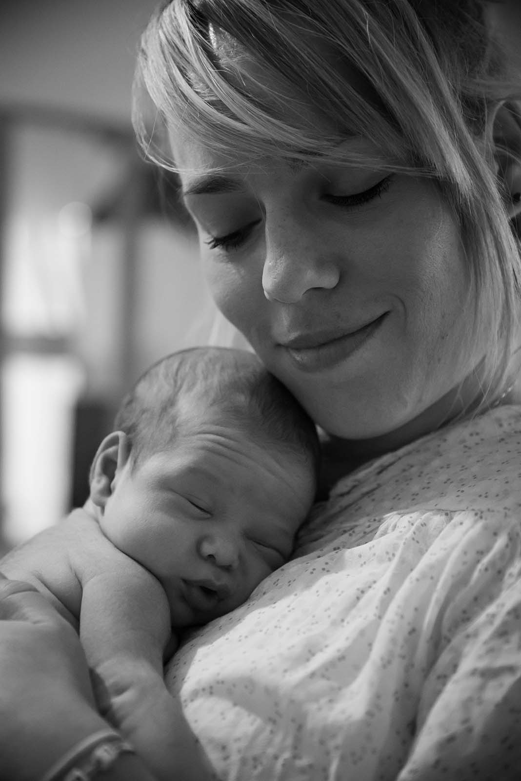 portrait noir et blanc d'un bébé appuyé sur sa maman
