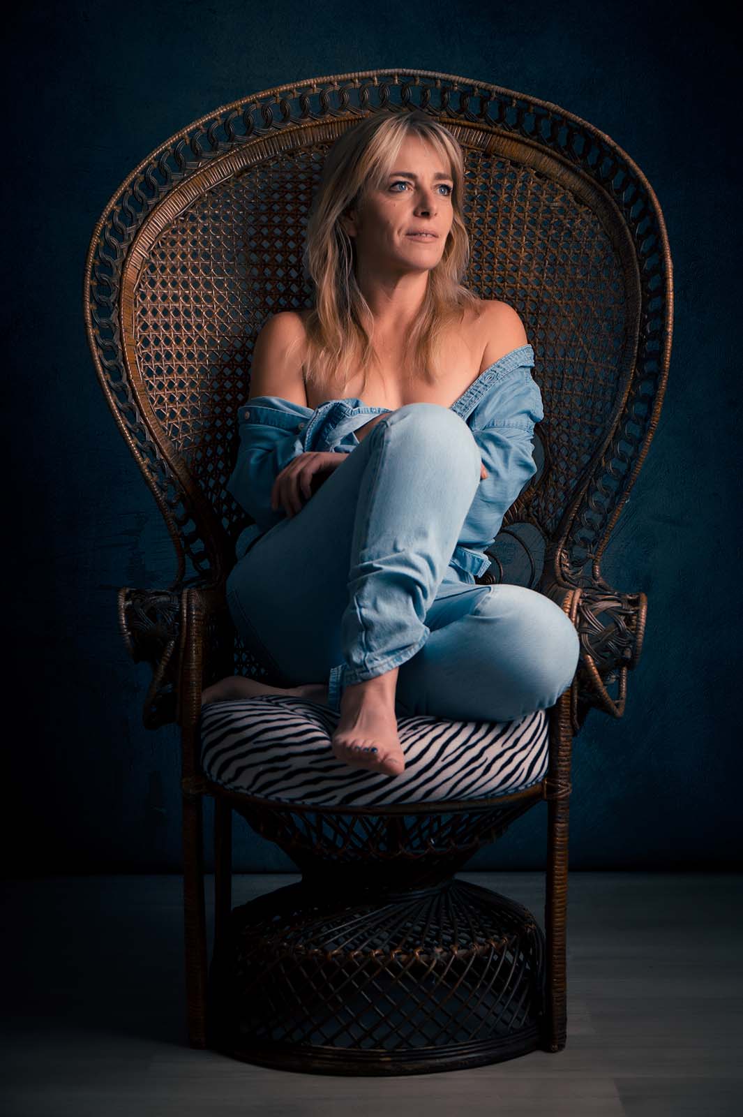 portrait d'une femme blonde habillée tout en jean assise dans un fauteuil Emmanuelle