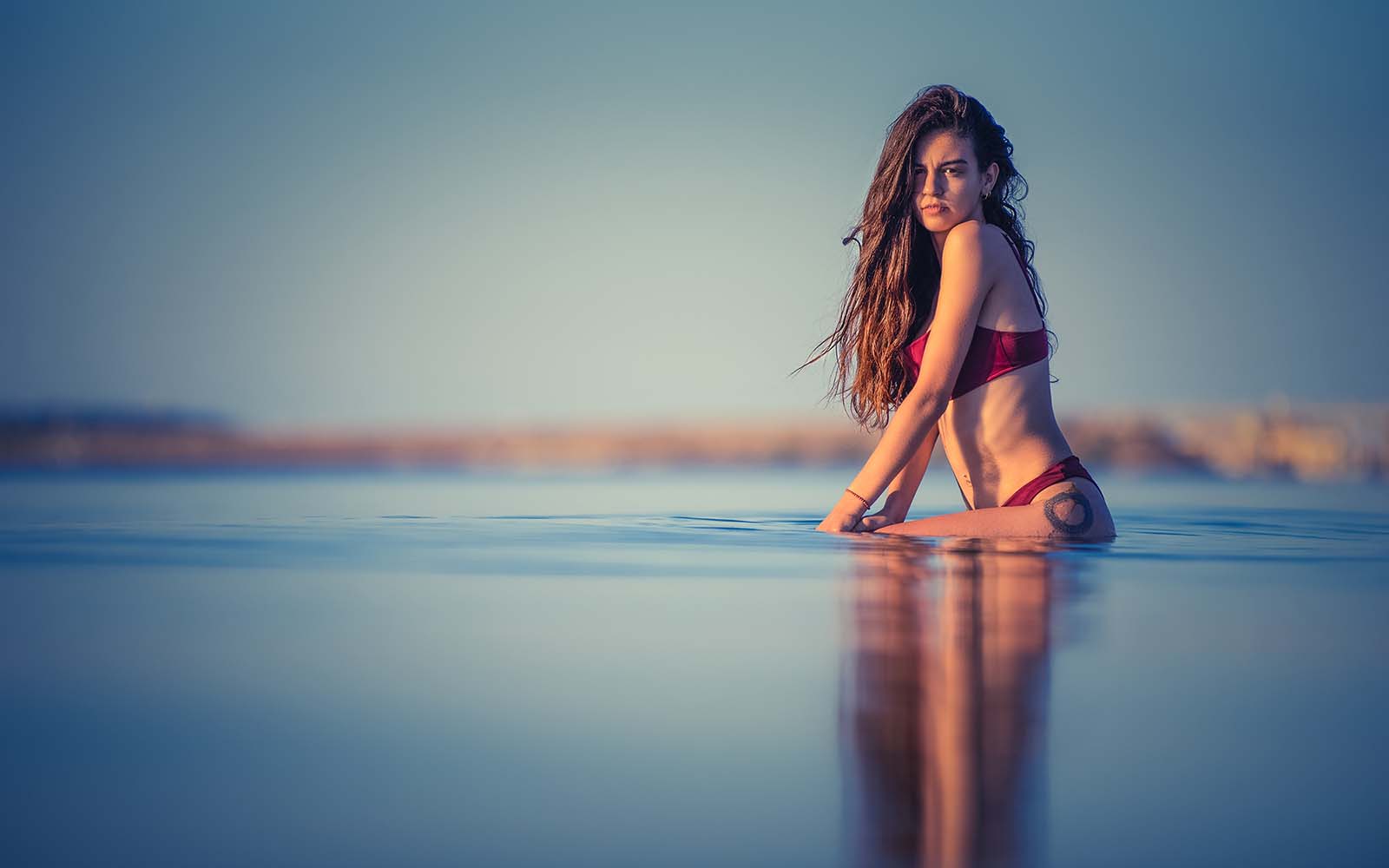 portrait d'une femme en maillot de bain assise dans l'eau