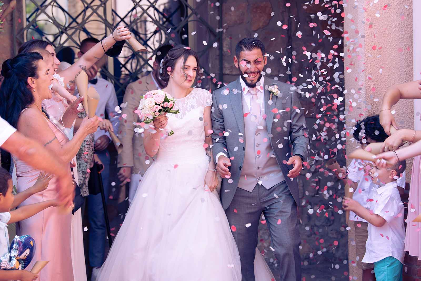 deux jeunes mariés sortant de la mairie sous une pluie de confettis