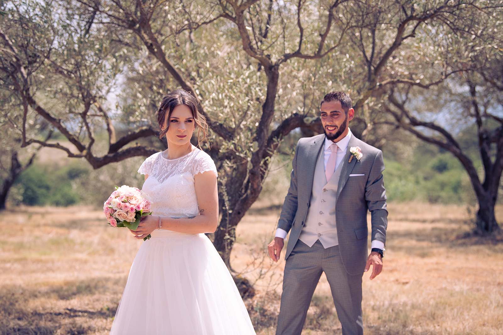 deux jeunes mariés dans un champ d'olivier