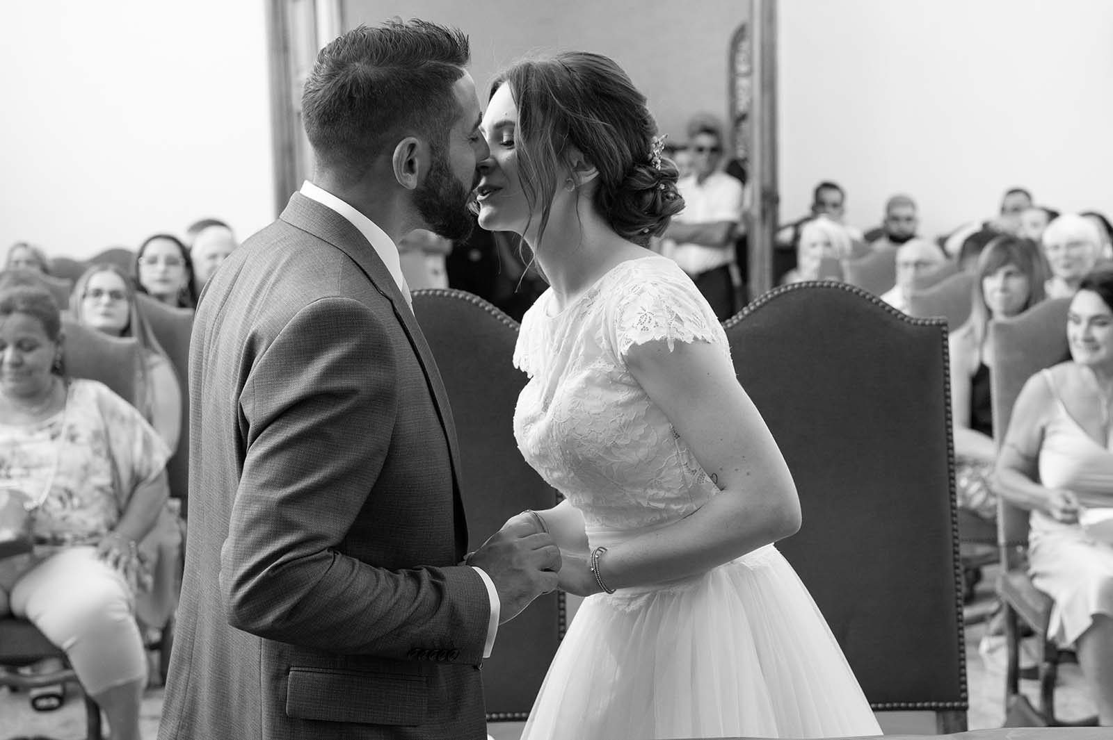 photo noir et blanc d'un couple de mariés en train de s'embrasser lors de la cérémonie civile de leur mariage