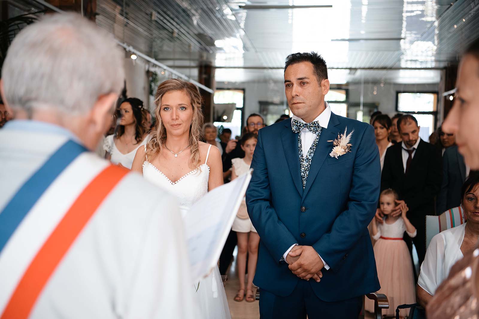 deux mariés se tenant debout face au maire lors de la cérémonie civile