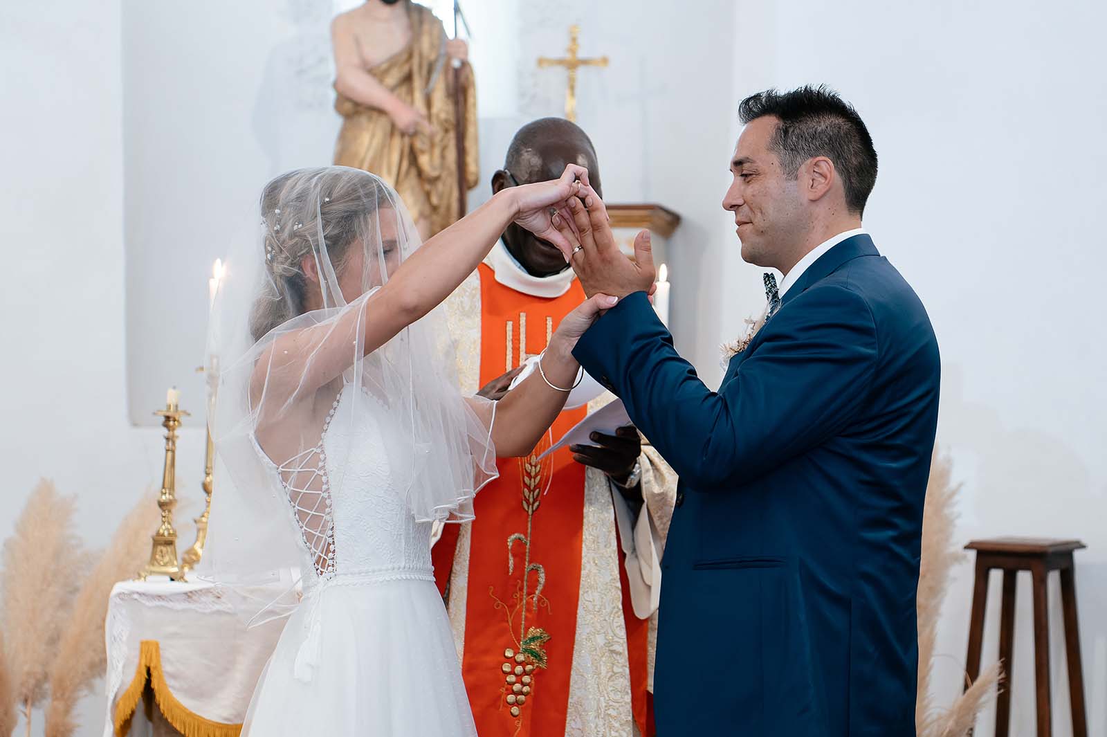 mariée enfilant l'alliance à son marie lors de la cérémonie religieuse