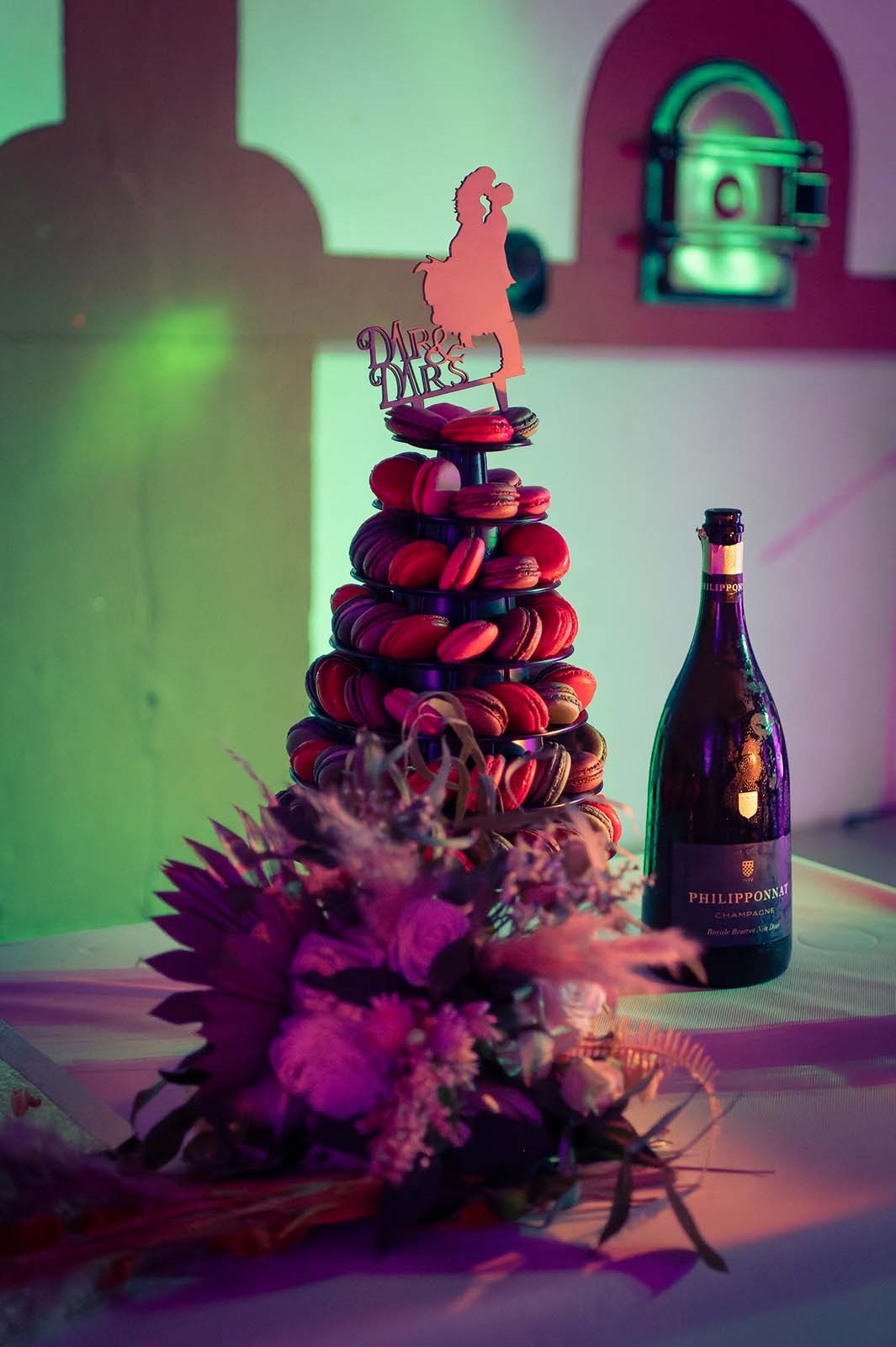 gros plan sur une pyramide de macarons avec à coté une bouteille de champagne