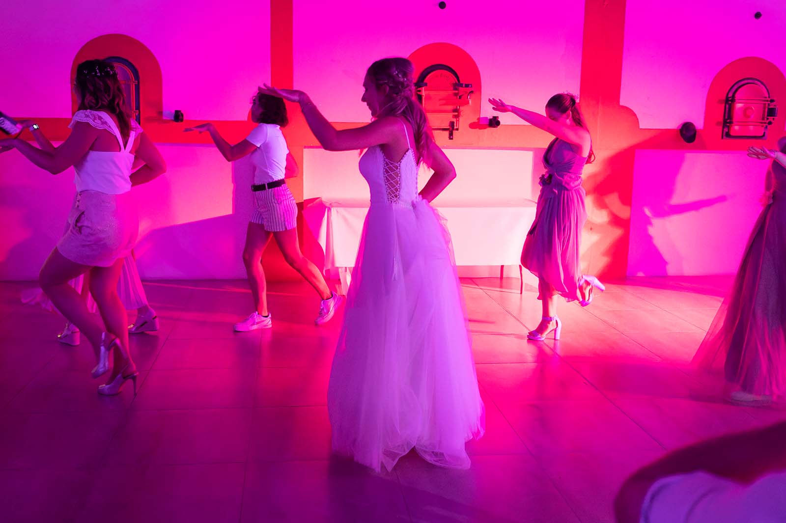 groupe de femmes en train de danser avec une mariée en premier plan