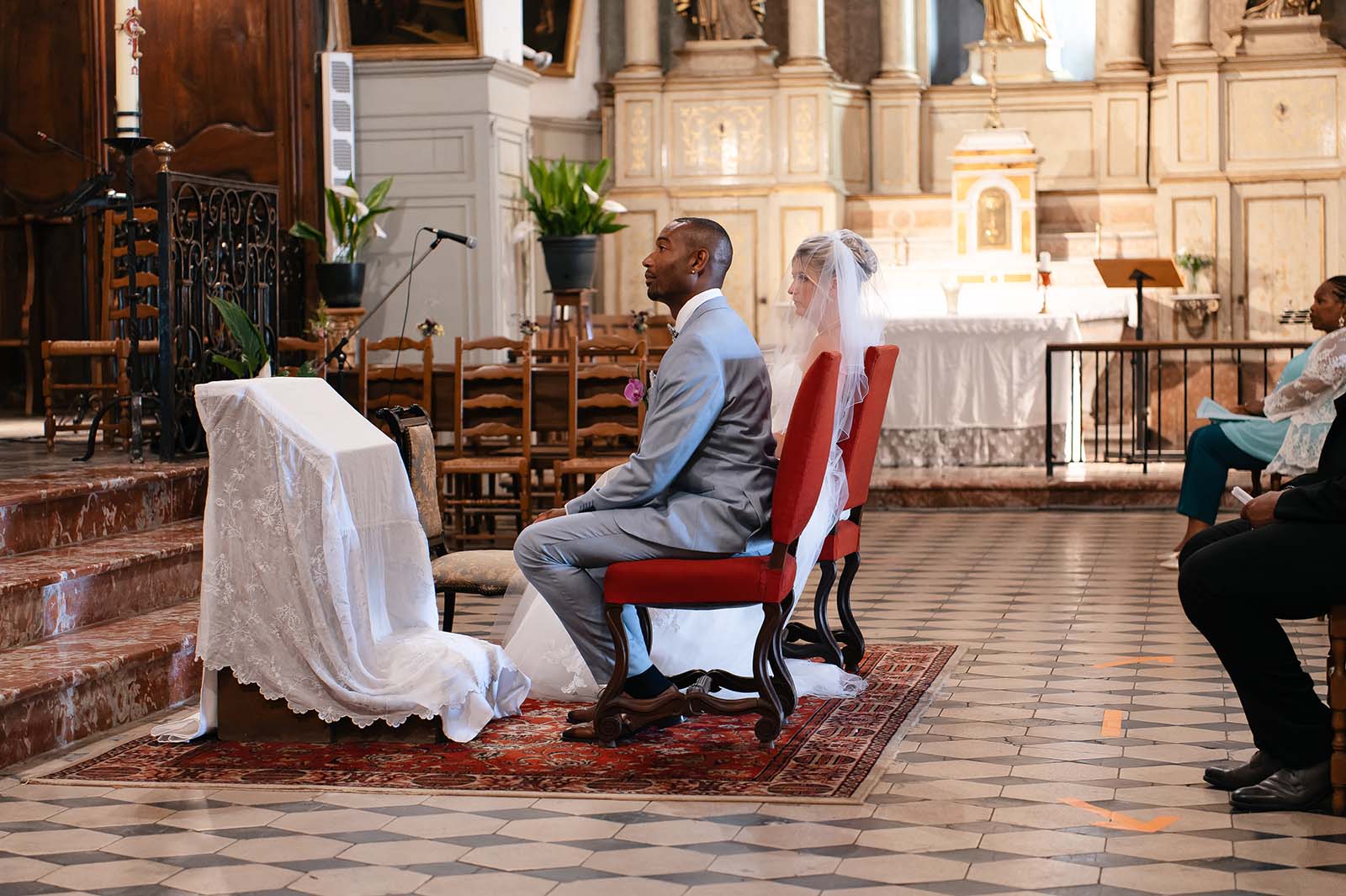 couple de mariés assis durant la cérémonie religieuse d'un mariage