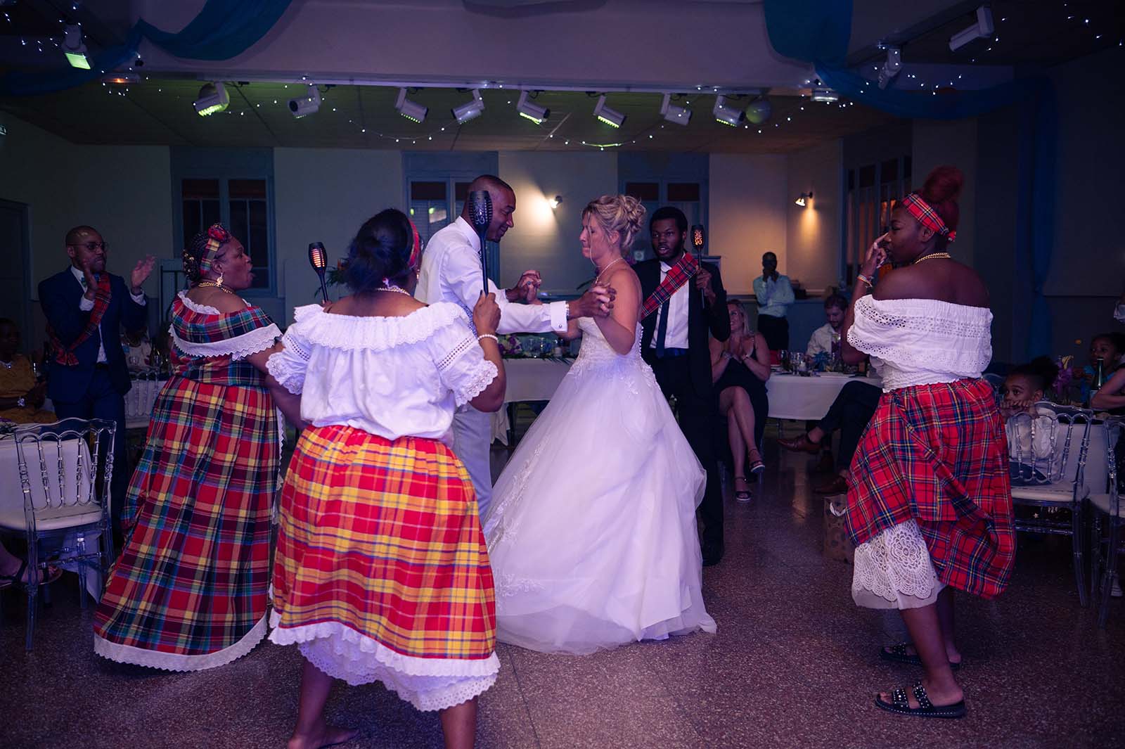 deux mariés en train de danser entourés de femme en costume créole