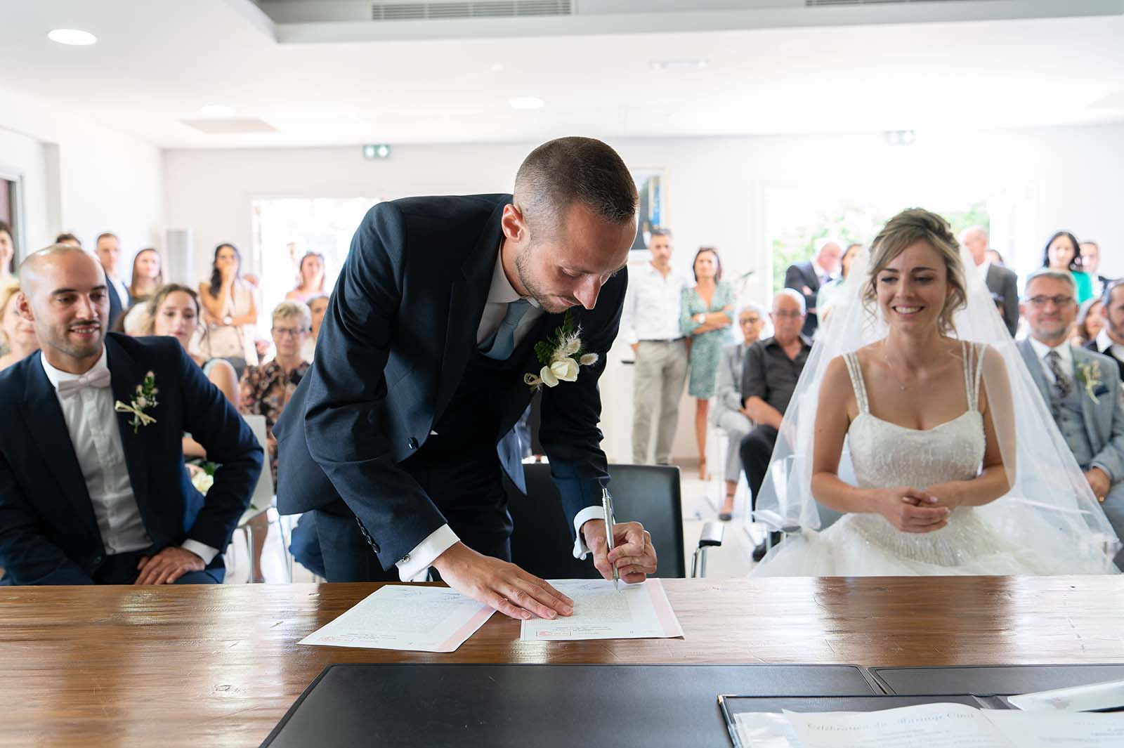 cérémonie civile d'un mariage où le marié signe le registre de mariage