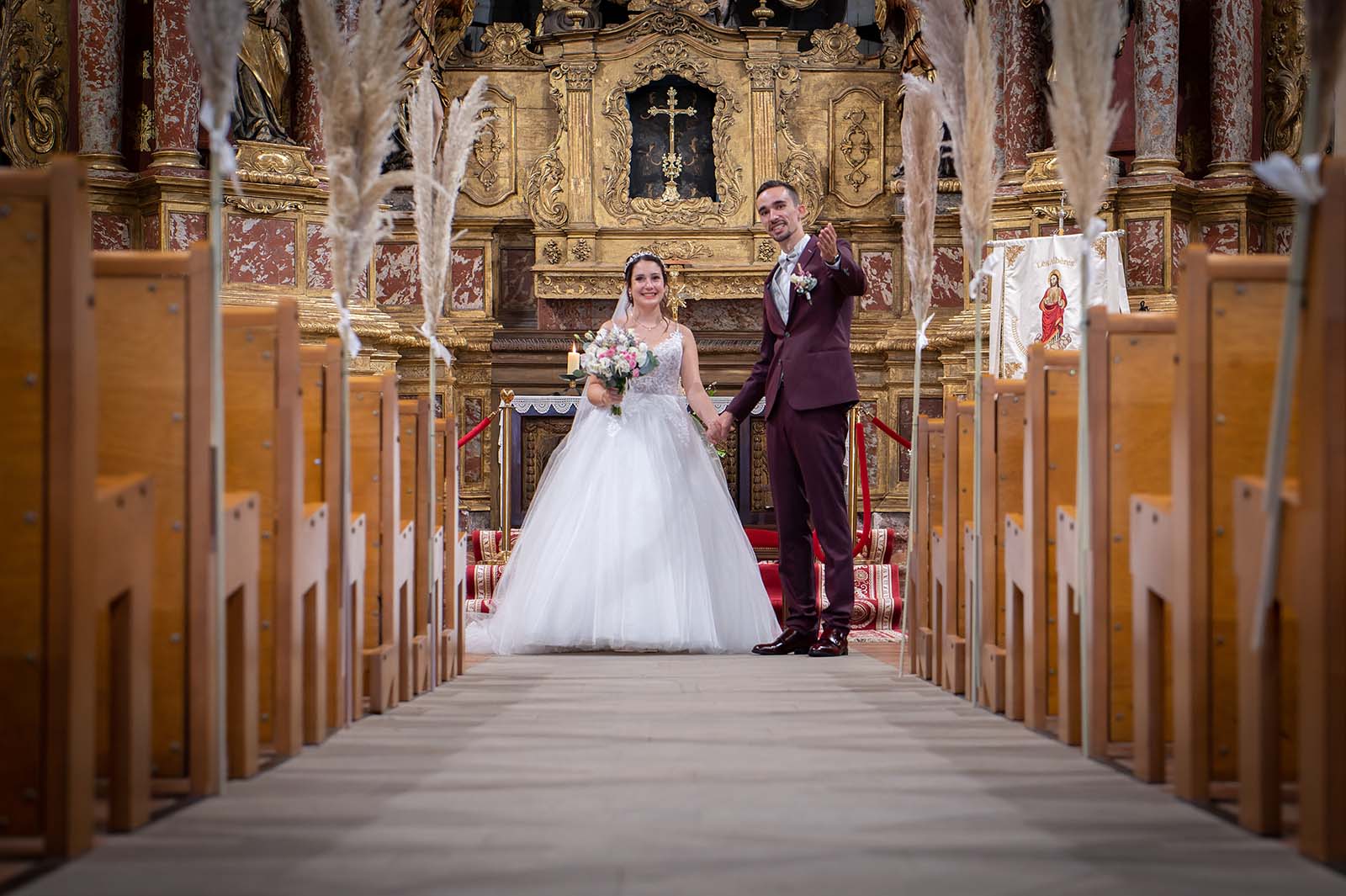 photos de mariés dans l'allée de l'église