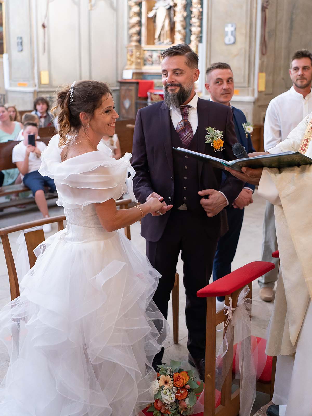 mariés se tenant la main dans une église