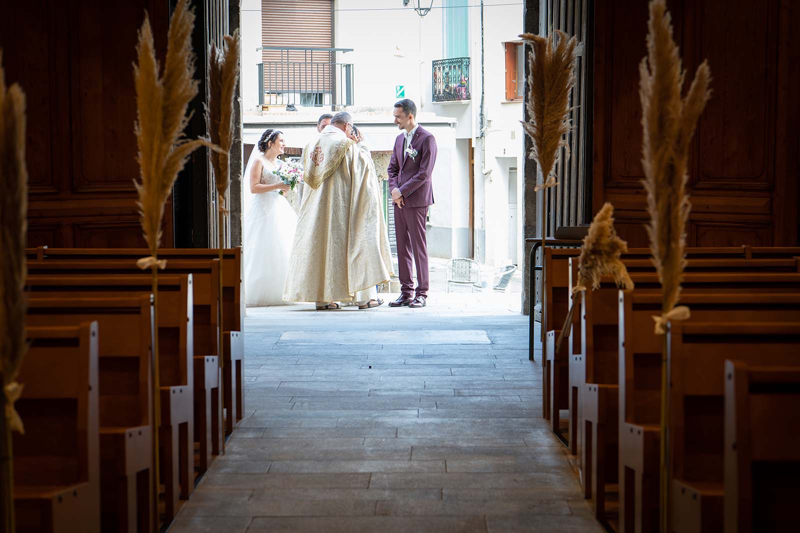 Photo du marié avec le curé à l'entré de l'église