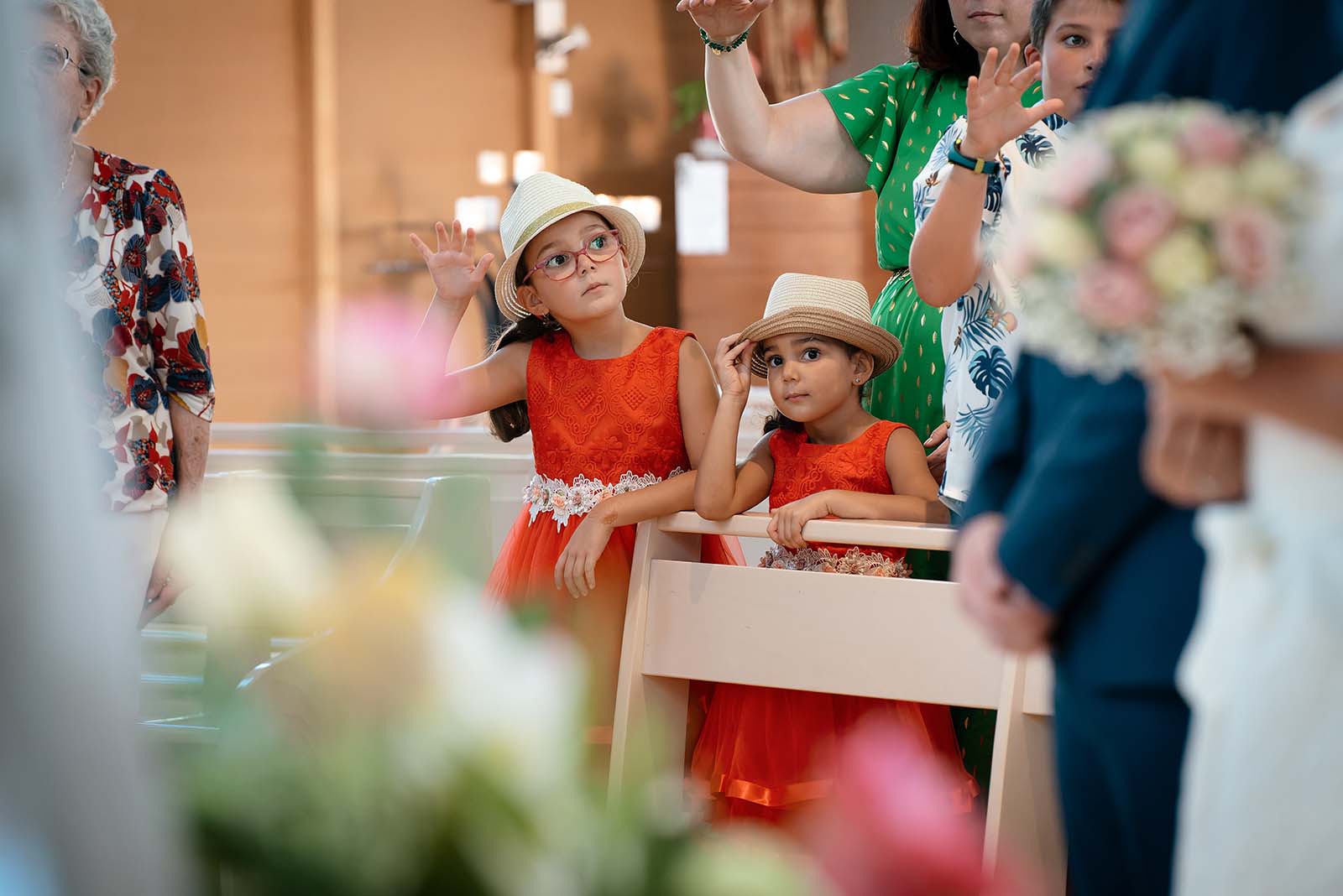 deux petites filles habillées en robe rouge et portant un chapeau de paille