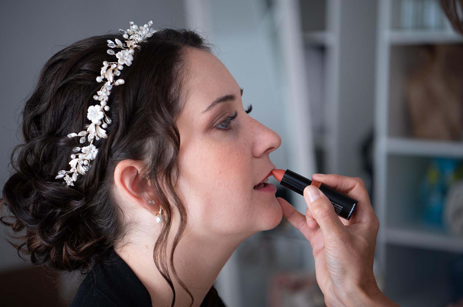 photo d'une mariée en train de se faire maquiller les lèvres