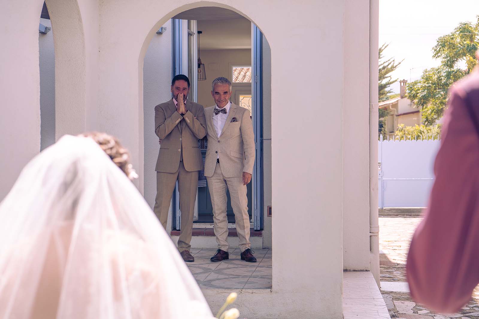 deux homme en costumes regardant une mariée