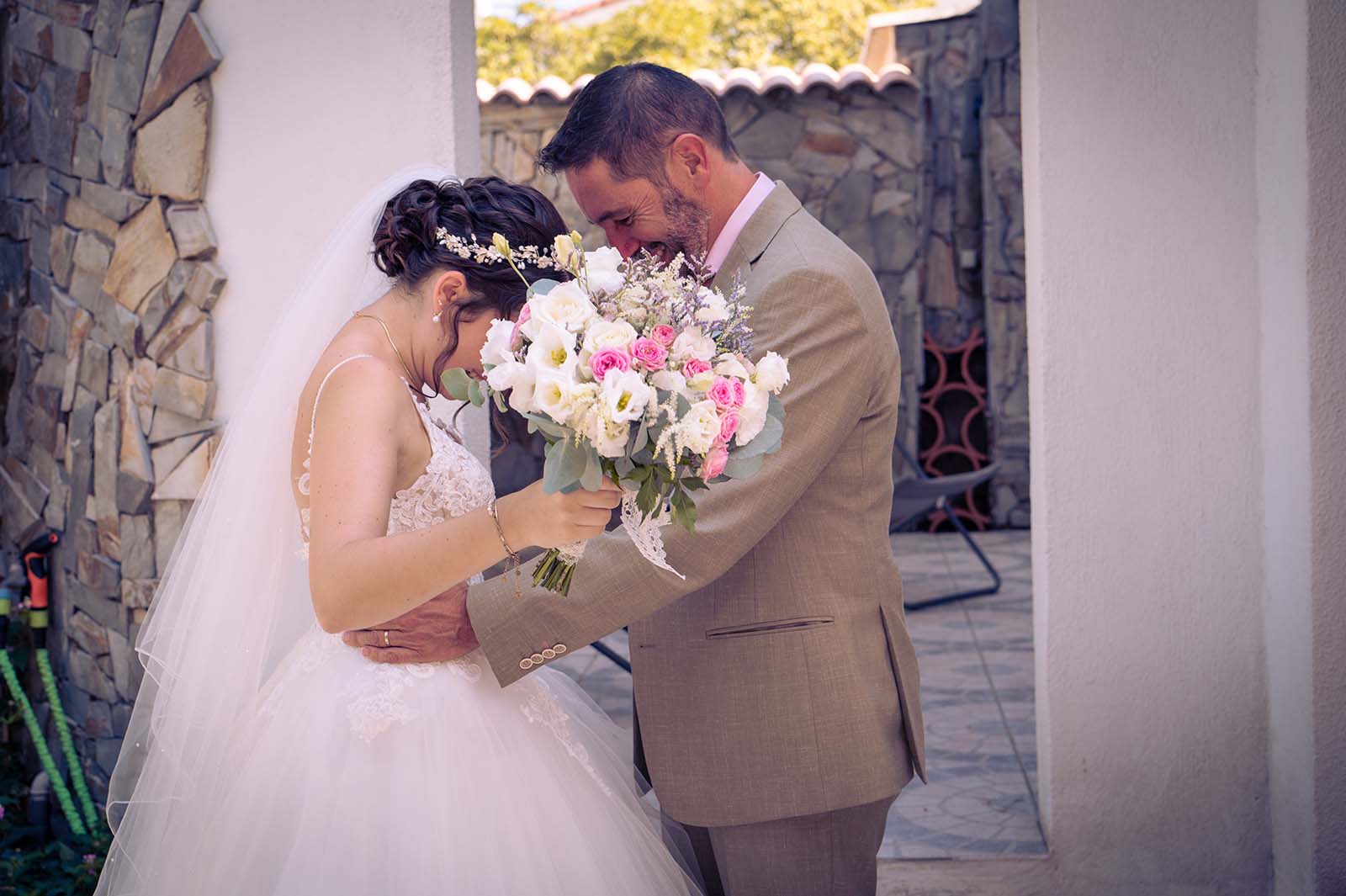 un papa prenant dans ses bras sa fille habillée en robe de mariée
