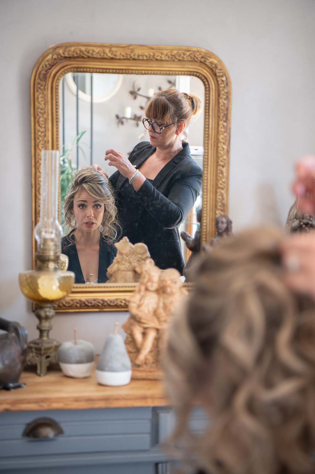 reflet dans le miroir d'une dame se faisant coiffer