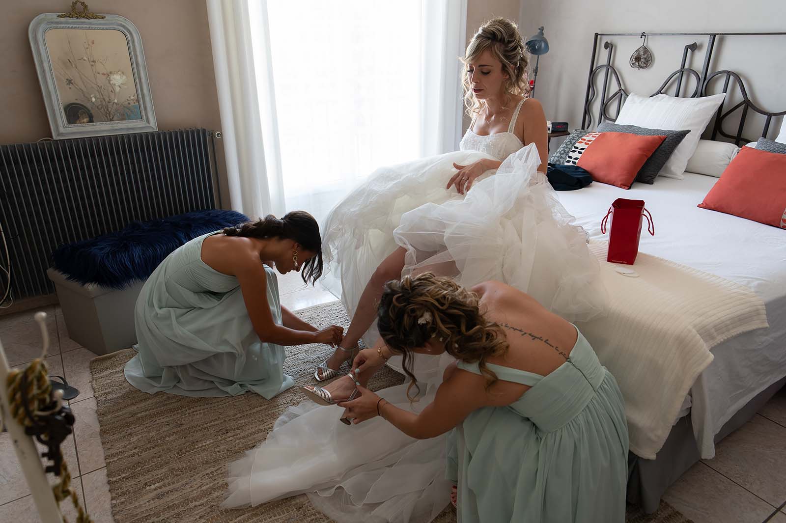 deux jeunes filles enfilant les chaussures à une mariée