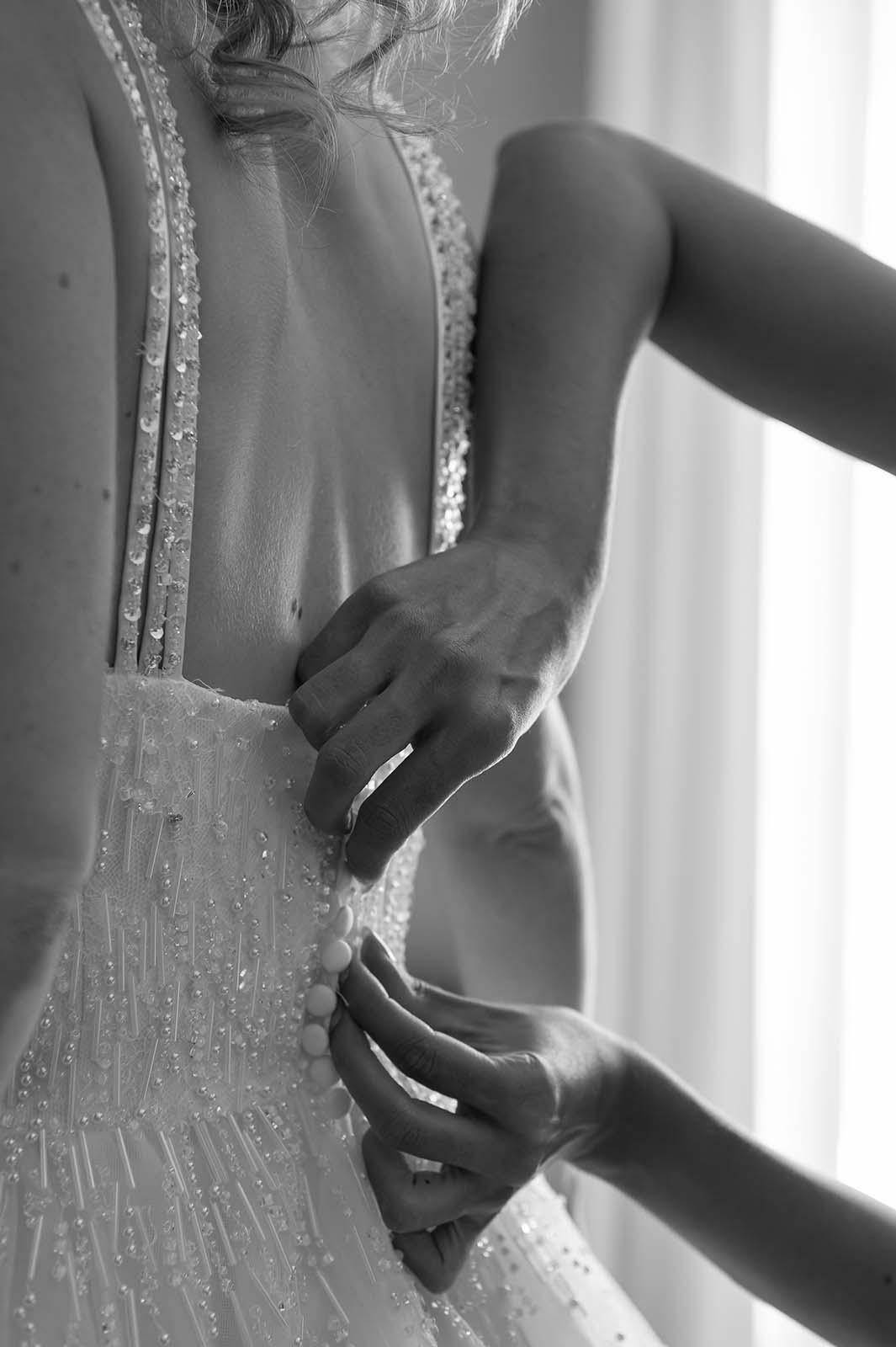 accrochage des boutons d'une robe de mariée