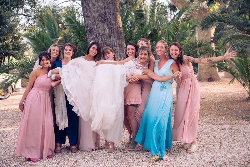 photo d'un groupe de femmes lors d'un mariage où elles portent la mariée