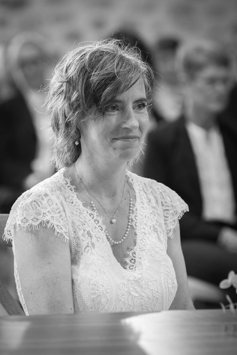 photo noir et blanc d'une mariée assise et qui sourit