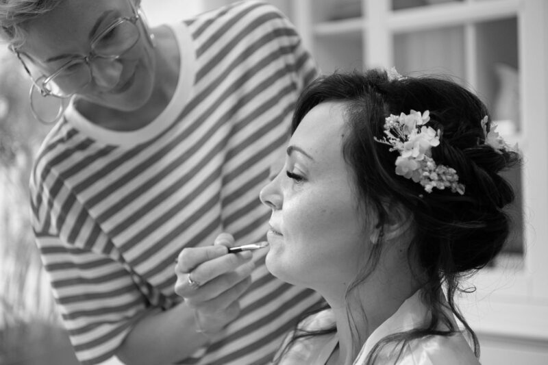 portrait noir et blanc de profil d'une femme en train de se faire maquiller