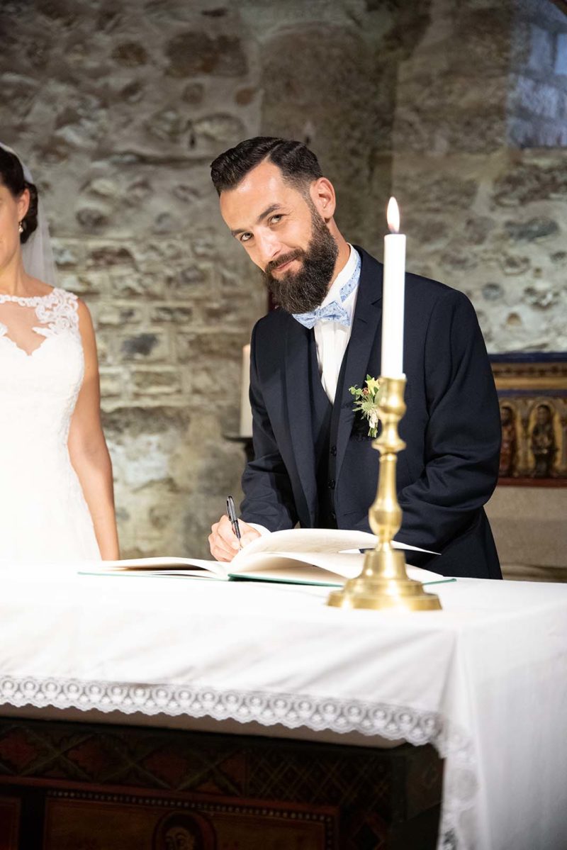 un marié signant le registre de mariage à l'église