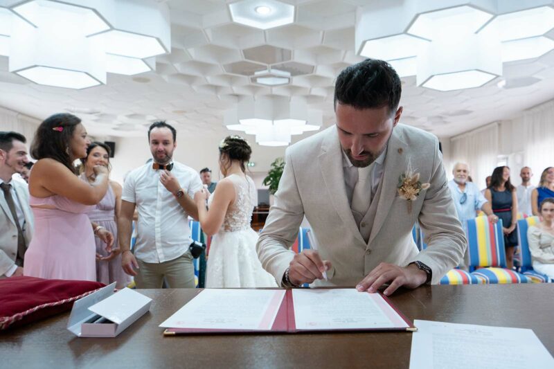 marié signant le registre de mariage lors de la cérémonie civile