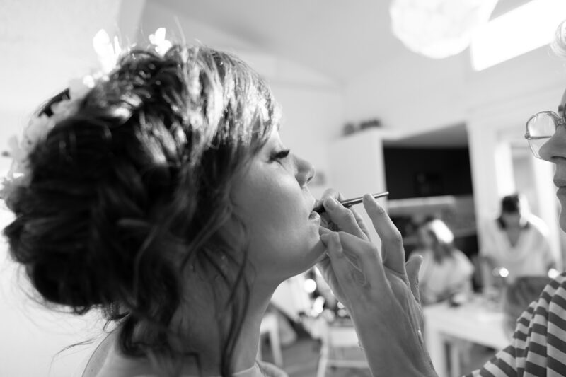 photo noir et blanc d'un dame en train de se faire maquiller les lèvres