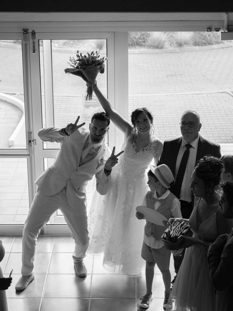 photo noir et blanc prise en plongée de deux mariés faisant une grimace