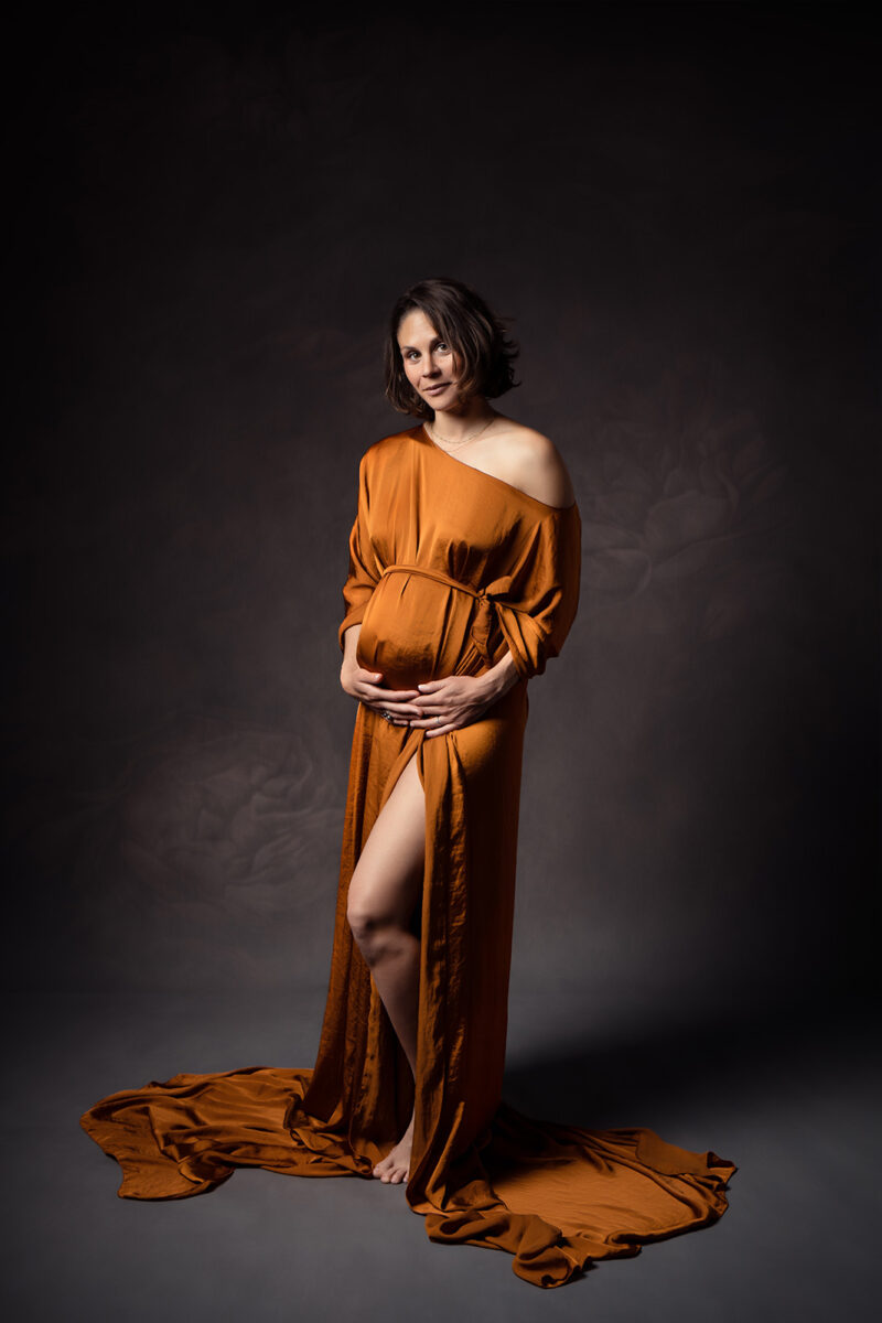 portrait d'une femme enceinte portant une longue cape de couleur cognac
