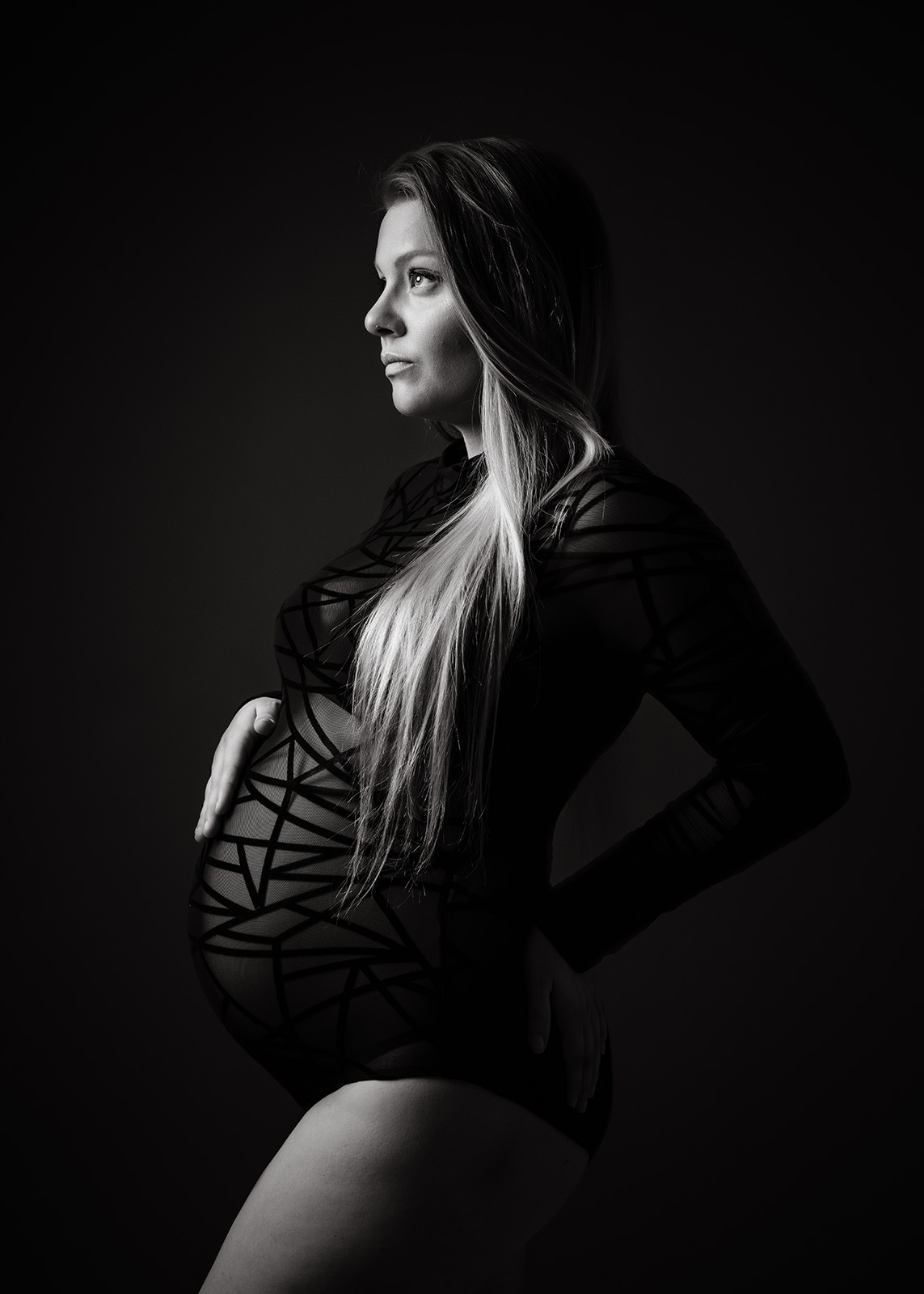 photo noir et blanc d'une femme enceinte blonde en body noir
