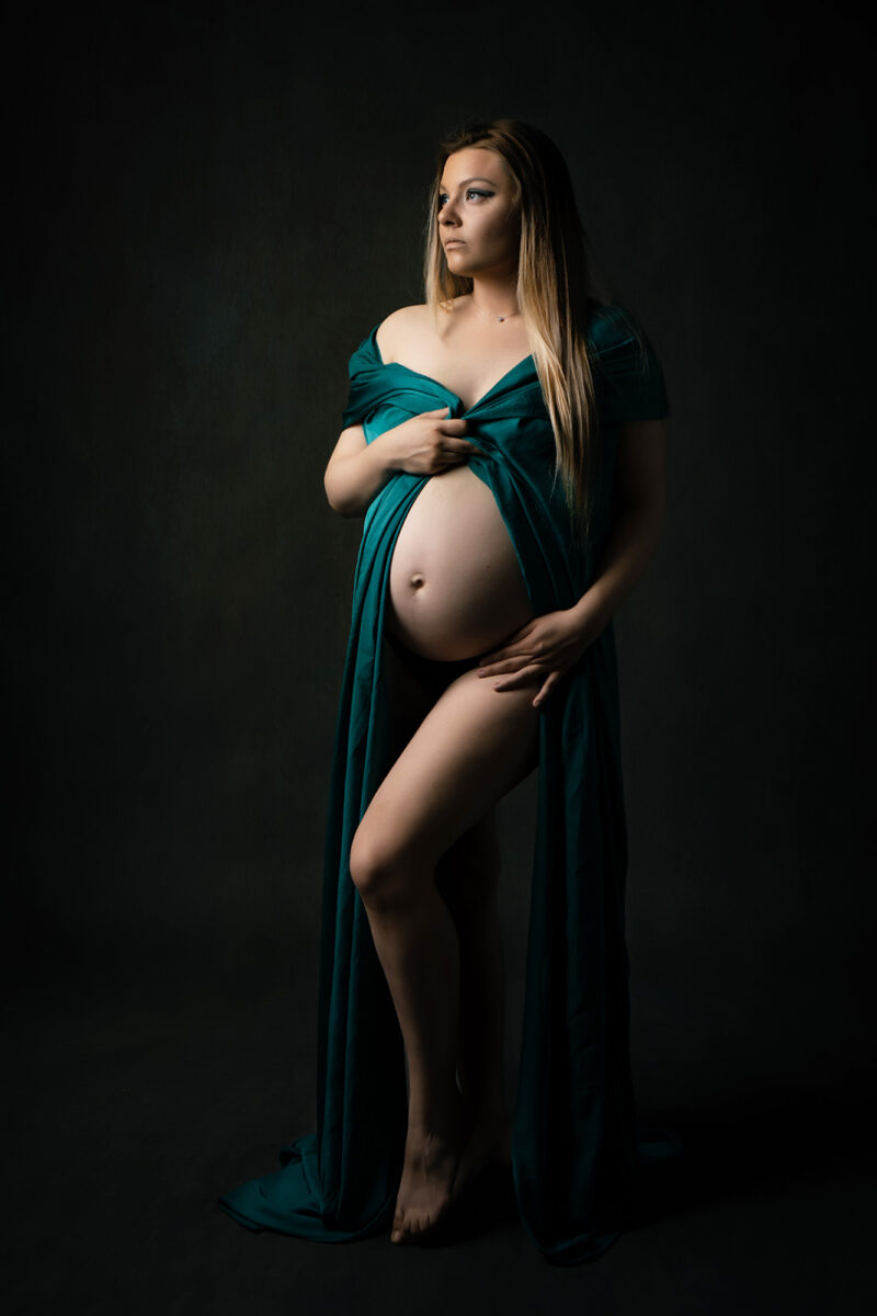 séance photo femme enceinte blonde sur fond texturé habillé d'un tissu vert